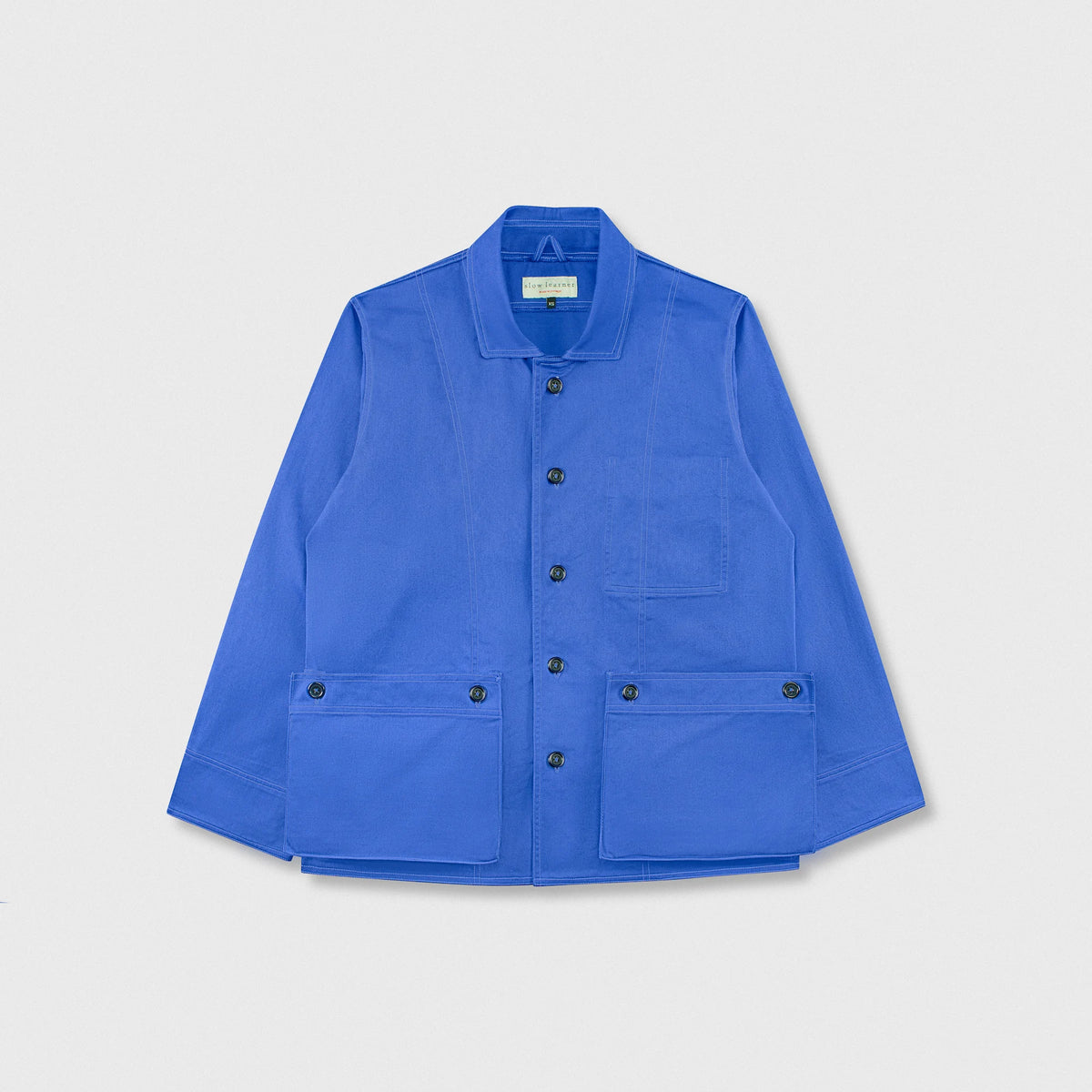 A bright blue utility jacket with a pointed collar, button front, and two large front flap pockets, shown flat on a light gray background.